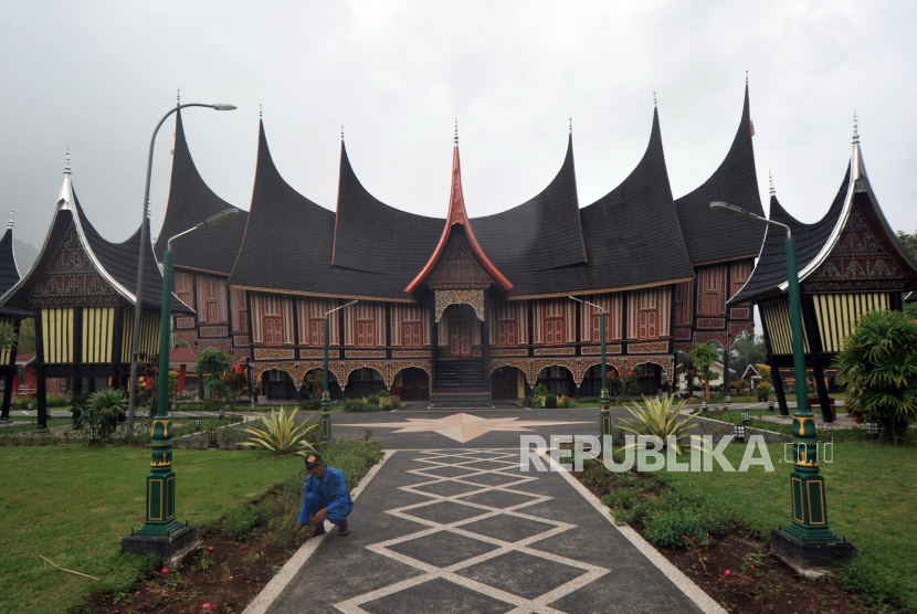 Pekerja membersihkan rumput di halaman Pusat Dokumentasi dan Informasi Kebudayaan Minangkabau (PDIKM) yang ditutup di Padangpanjang, Sumatera Barat, Ahad (22/3/2020). .