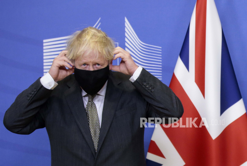 Perdana Menteri Inggris Boris Johnson berdiri di sebelah bendera Union Jack. Inggris ancam hapus beberapa ketentuan perjanjian pasca-Brexit dengan Irlandia Utara. Ilustrasi.