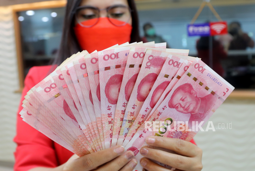  Seorang karyawan memegang uang kertas Yuan di money changer Ayu Masagung di Jakarta, Selasa (7/9/2021). Yuan menjadi mata uang yang paling banyak digunakan untuk transaksi lintas batas di China pada Maret.