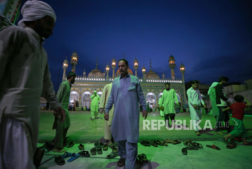 Jemaah Muslim meninggalkan masjid setelah berbuka puasa dan menghadiri sholat isya, selama bulan puasa Ramadhan, di Rawalpindi, Pakistan, Rabu, 14 April 2021.