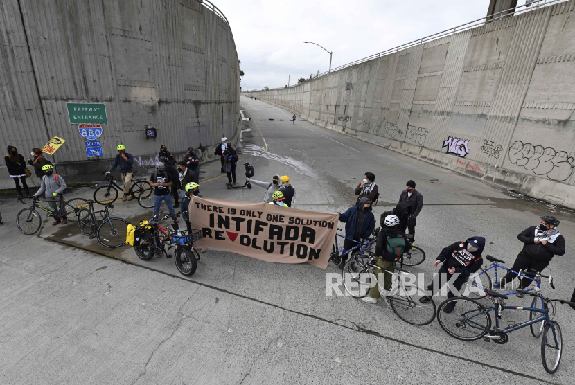 Para pengunjuk rasa yang menentang perang di Gaza memblokir jalan Interstate 880 menuju selatan di Oakland, California, Senin, (15/4/2024).