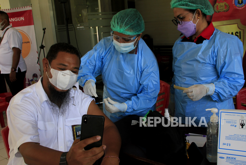 Seorang pegawai Balai Wilayah Sungai (BWS) NT II mengabadikan momen saat mendapatkan suntikan vaksin COVID-19 dosis pertama di Kota Kupang, NTT, Kamis (25/3/2021). Kementerian PUPR melakukan vaksinasi COVID-19 dosis pertama bagi 400 pegawainya yang tersebar di lima balai di Kota Kupang dalam rangka mensukseskan program vaksinasi. ANTARA FOTO/Kornelis Kaha/wsj.