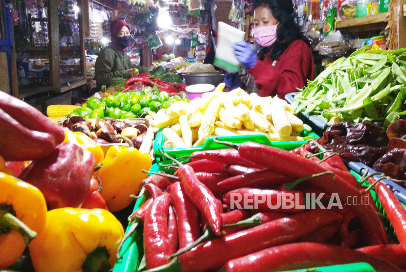 Pedagang melayani pembeli di kios sayuran. Foto Ilustrasi
