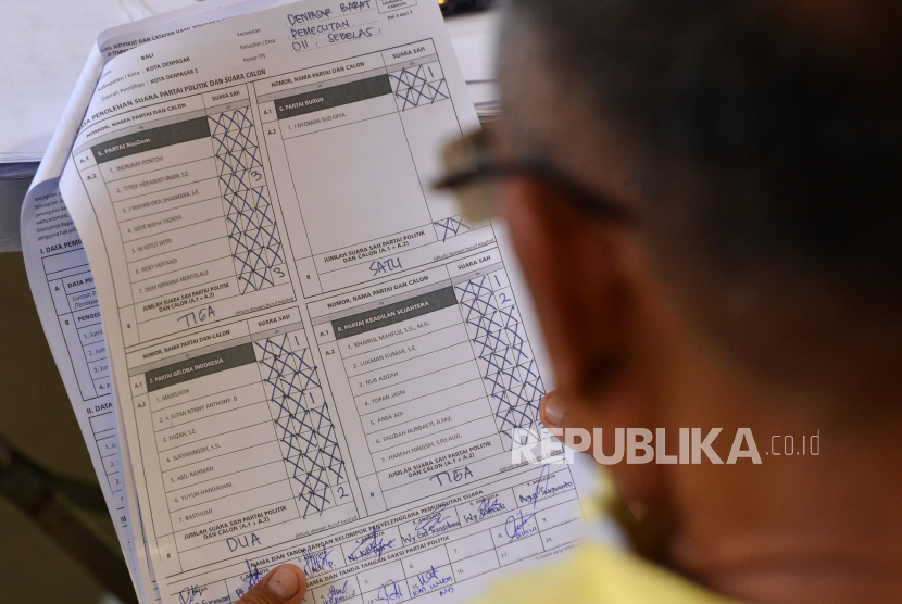 Petugas saksi dari partai politik mengamati data perolehan suara Pemilu 2024 di Denpasar, Bali, Selasa (20/2/2024). Banyak petugas KPPS yang jatuh sakit, bahkan meninggal.