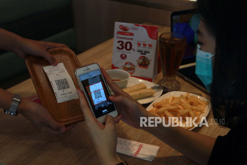 Pengunjung melakukan transaksi pembayaran nontunai dengan menggunakan Scan QRIS di salah satu restoran di Bintaro Jaya, Tangerang Selatan, Banten, Selasa (9/3). Dana Moneter Internasional (IMF) memperingatkan ada risiko yang perlu diperhatikan dari mata uang digital.