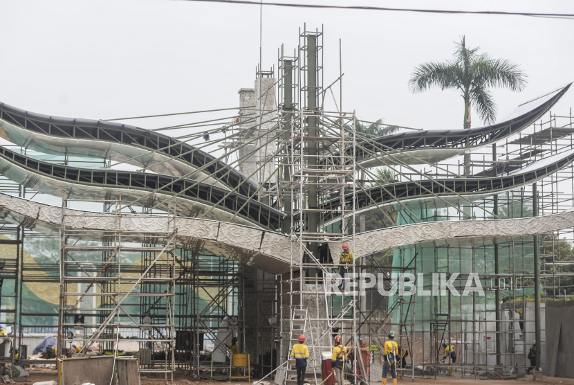 Sejumlah pekerja menyelesaikan revitalisasi gerbang depan Taman Mini Indonesia Indah (TMII), Jakarta Timur, Selasa (12/7/2022).