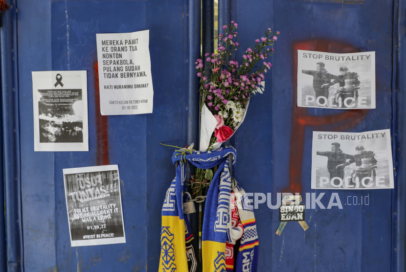 Bunga dan plakat digantung di pintu masuk tribun untuk menyampaikan belasungkawa kepada para korban kerusuhan dan penyerbuan di Stadion Kanjuruhan di Malang, Jawa Timur, Indonesia, 04 Oktober 2022.