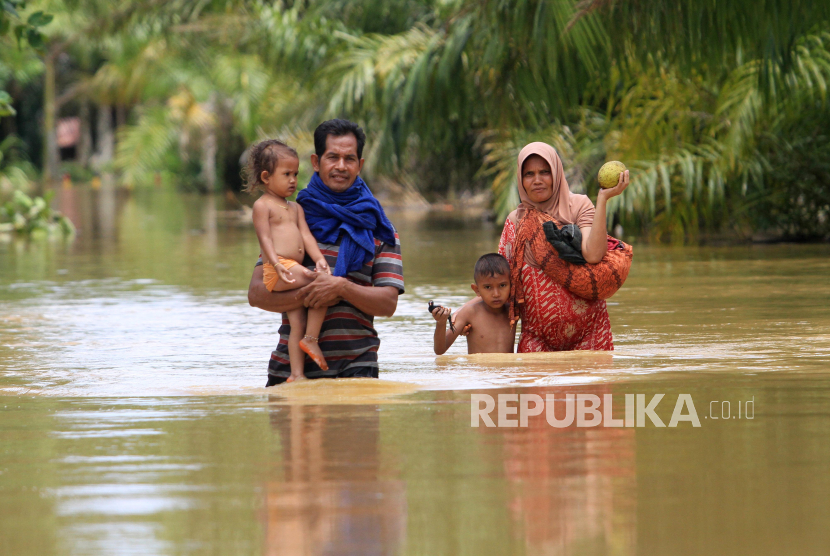 Dua warga bersama anaknya berusaha melintasi banjir di Desa Napai, Woyla Barat, Aceh Barat, Aceh, Ahad (7/5/2023). 