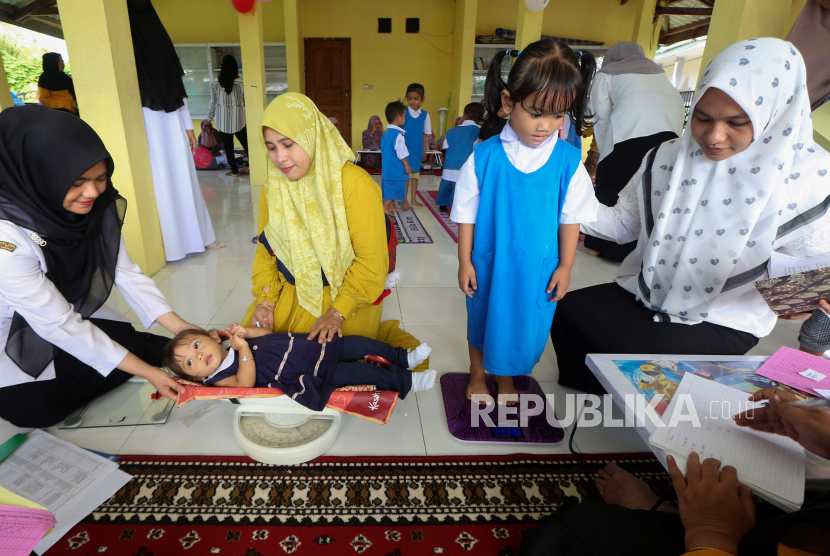 Petugas kesehatan dan kader posyandu menimbang bayi dan balita pada aksi timbang serentak untuk pencegahan stunting di gampong (desa) Pande, Banda Aceh, Aceh, Rabu (2/8/2023). Aksi timbang serentak di seluruh posyandu itu untuk menurunkan angka stunting nasional yang ditargetkan Kementerian Kesehatan dari 21,6 persen pada tahun 2022 menjadi 14 persen pada 2024 mendatang. 