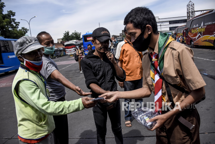 Sejumlah pelajar memberikan masker kepada warga saat Kampanye Penggunaan Masker di Terminal Cicaheum, Kota Bandung, Selasa (3/11). Kampanye tersebut sebagai ajakan kepada masyarakat untuk membiasakan diri memakai masker agar terhindar dari penularan Covid-19. Foto: Abdan Syakura/Republika