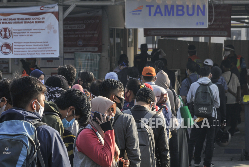 Sejumlah penumpang KRL ( Kereta Rel Listrik ) Commuter Line  antre menuju pintu masuk Stasiun Tambun, Kabupaten Bekasi, Jawa Barat, Senin (22/6/2020). Antrean calon penumpang ini akibat adanya pembatasan jumlah penumpang di dalam rangkaian KRL