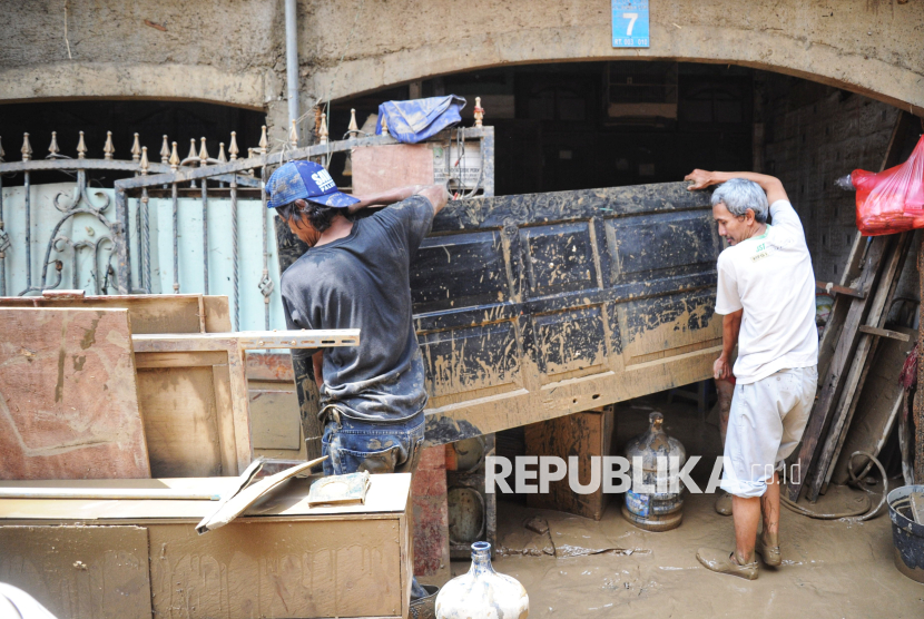 Warga membersihkan lumpur sisa banjir di Perumahan Pondok Gede Permai, Bekasi, Jawa Barat, Rabu (5/3/2025). Banjir dikawasan tersebut sudah surut dan menyisakan lumpur berwarna kecoklatan di jalan dan rumah-rumah warga. Sebagian warga mulai membersihkan sisa-sisa lumpur di rumah mereka. Menurut petugaa banjir di kawasan Pondok Gede Permai mulai surut pada Rabu (5/3/2025) dini hari, pada pukul 01.00 WIB. Sebelumnya, banjir di titik ini jadi salah satu yang terparah dengan ketinggian air mencapai 3 meter.