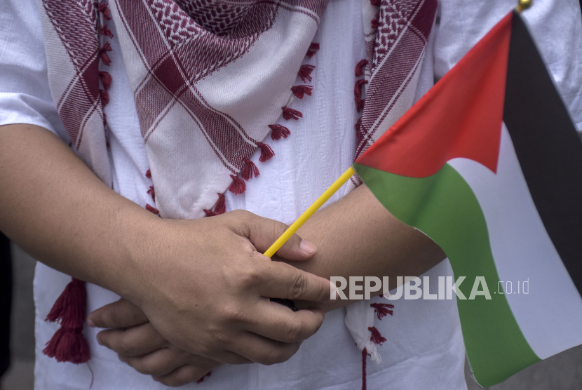 Warga memegang bendera Palestina saat Doa Bersama dan Solidaritas Untuk Palestina Jumat (24/11/2023). 