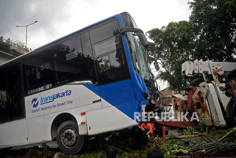 Sejumlah petugas berusaha mengevakuasi bus Transjakarta Koridor 11 jurusan Kampung Melayu-Pulogebang yang mengalami kecelakaan di Jalan I Gusti Ngurah Rai, Kecamatan Duren Sawit, Jakarta, Jumat (11/2/2022).