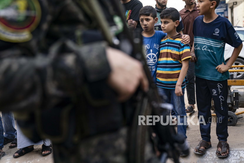 Anak-Anak Penghafal Alquran Pawai di Jalanan Gaza. Foto ilustrasi:  Anak-anak menyaksikan para militan Hamas berparade di jalan-jalan untuk Bassem Issa, seorang komandan Hamas, yang dibunuh oleh tindakan militer Angkatan Pertahanan Israel sebelum gencatan senjata dicapai setelah perang 11 hari antara penguasa Hamas Gaza dan Israel, di Gaza City, Sabtu, 22 Mei 2021.