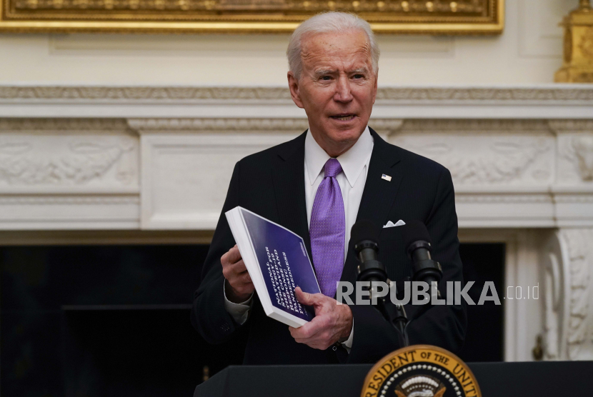  Presiden Joe Biden memegang buklet saat berbicara tentang virus corona di Ruang Makan Negara Gedung Putih, Kamis, 21 Januari 2021, di Washington.