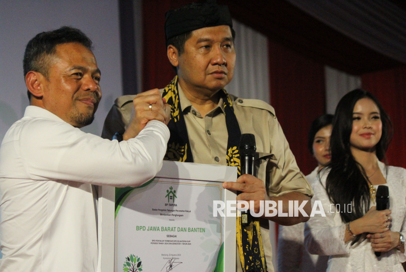 Dirut Bank BJB Yusuf Saadudin menerima penghargaan dari Meteri PKP Maruarar Sirait sebagai BPD Penyalur Terbesar KPR Sejahtera FLPP saat akad massal dan serah terima kunci 1.080 debitur Fasilitas Likuiditas Pembiayaan Perumahan (FLPP) Bank BJB dan BJB Syariah, di Aula Kahatex, Jalan Rancaekek, Kabupaten Sumedang, Jumat (22/8/2025). KPR FLPP ini merupakan bagian program pemerintah 3 Juta Rumah untuk masyarakat berpenghasilan rendah bisa memiliki rumah subsidi.