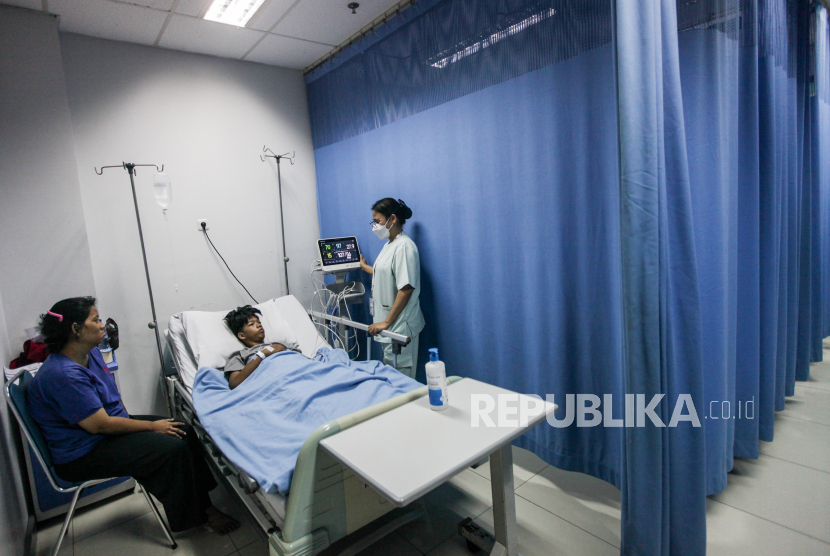 Tenaga kesehatan mengecek kondisi kesehatan pasien Demam Berdarah Dengue (DBD) di RSUD Taman Sari, Jakarta, Selasa (16/4/2024). Sebanyak 14 pasien kasus DBD dirawat di rumah sakit tersebut yang mayoritas 70 persen pasiennya merupakan anak-anak usia SD dan SMP. Peningkatan kasus DBD dimulai sejak Desember 2023 hingga mencapai puncaknya pada April 2024  yang diakibatkan musim hujan yang meningkatkan kelembapan udara sehingga nyamuk mudah berkembang biak.