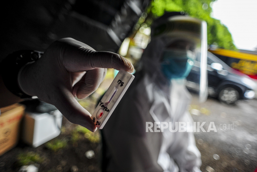 Petugas melihat hasil rapid test wisatawan di Kabupaten Bogor, Jawa Barat, Jumat (30/10).