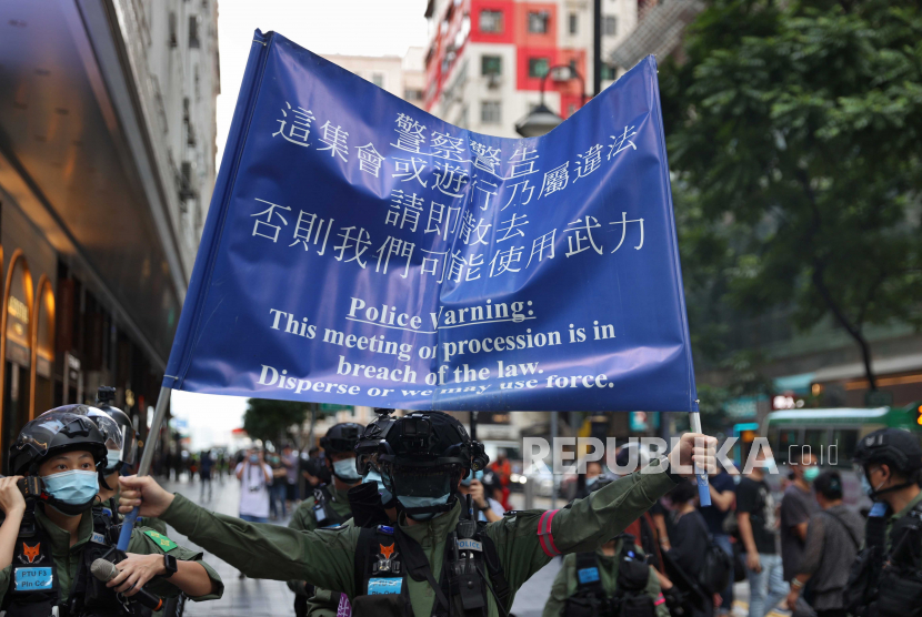  Petugas polisi mengibarkan bendera peringatan untuk membubarkan pengunjuk rasa di sepanjang jalan di Causeway Bay selama unjuk rasa terlarang pada Hari Nasional China, di Hong Kong, China, 01 Oktober 2020. 