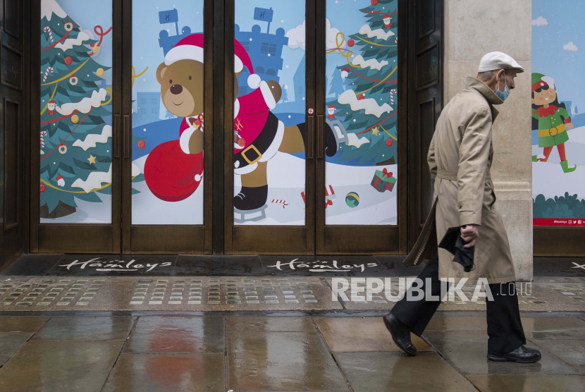 Seorang pria berjalan melewati toko-toko yang tutup di Regent Street, di London pada hari Senin 21 Desember 2020. Jutaan orang di Inggris telah belajar bahwa mereka harus membatalkan acara kumpul-kumpul Natal dan belanja liburan. Perdana Menteri Inggris Boris Johnson mengatakan pada hari Sabtu bahwa pertemuan liburan tidak dapat dilanjutkan dan toko-toko yang tidak penting harus tutup di London dan sebagian besar Inggris selatan.