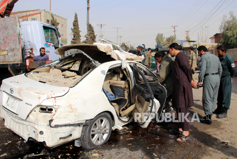  Pejabat keamanan Afghanistan memeriksa lokasi ledakan IED di Lashkargah, ibu kota provinsi Helmand, Afghanistan, 12 November 2020. Polisi mengatakan ledakan itu menargetkan kendaraan wartawan Ilyas Dayee, yang tewas dalam ledakan itu, dan tiga lainnya terluka setelahnya. sebuah bom merobek mobil di kota Lashkargah.