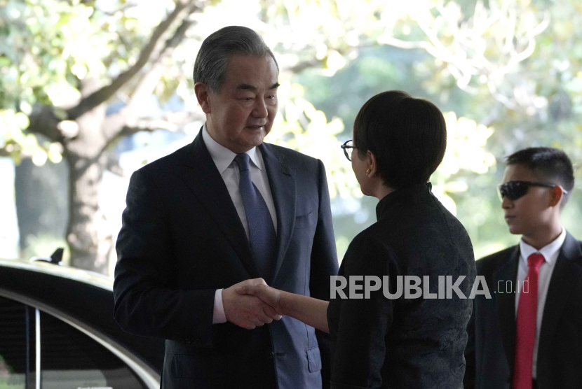 Indonesian Foreign Minister Retno Marsudi, center, greets Chinese Foreign Minister Wang Yi upon his arrival for their meeting in Jakarta, Indonesia, Thursday, April 18, 2024.  