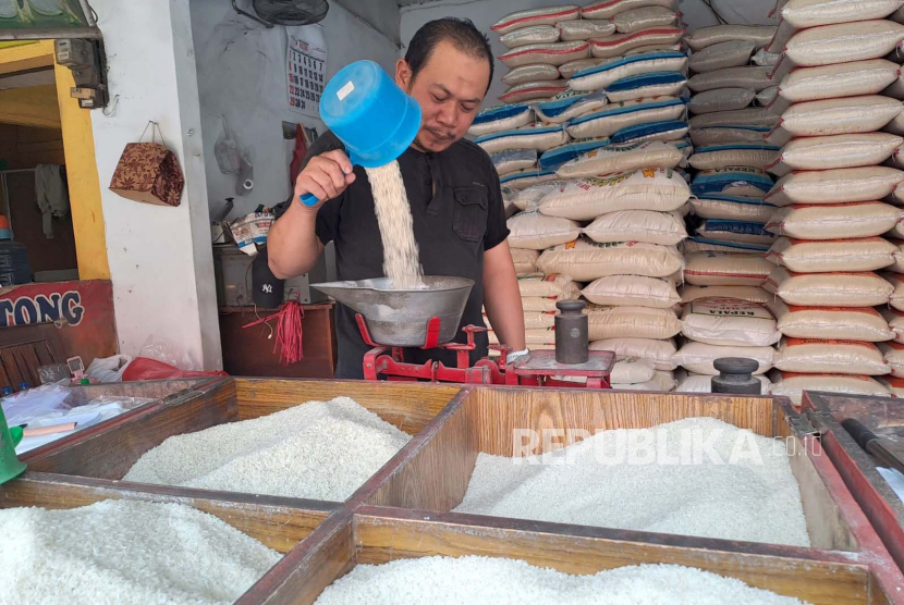 Seorang pedagang beras di Pasar Baru Indramayu, Hadi (46) sedang menimbang beras, Senin (9/10/2023). 