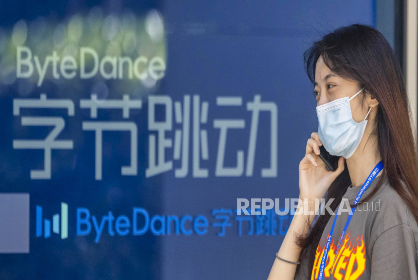 Seorang wanita menggunakan teleponnya di depan gedung markas Bytedance di Shanghai, Cina, 3 Agustus 2020. Perusahaan Induk TikTok akan Perbanyak Investasi Masuki Bisnis Virtual Reality