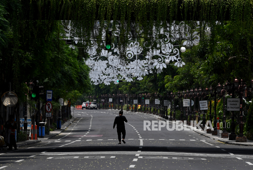 Warga melintas di Jalan Tunjungan yang ditutup, di Surabaya, Jawa Timur, Sabtu (28/3/2020). Penutupan sejumlah jalan di Surabaya tersebut agar terbebas dari segala aktivitas warga dan kendaraan guna mencegah penyebaran Virus Corona (COVID-19)
