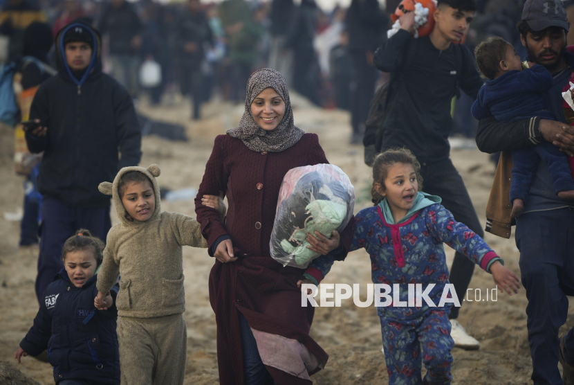 Seorang Ibu Palestina bersama anak-anaknya berjalan kaki pulang kembali menuju rumah mereka di Jalur Gaza Utara, Senin (27/1/2025). Ribuan warga Palestina untuk pertama kalinya kembali ke rumah mereka di wilayah Gaza Utara yang sebelumnya ditutup oleh Israel.