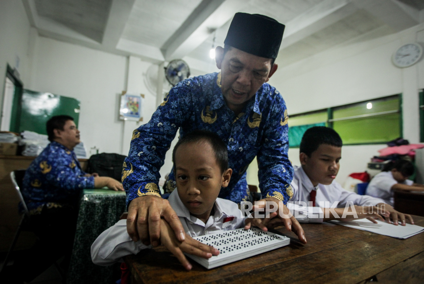 Guru mengajarkan siswa membaca huruf braile saat hari pertama sekolah di SLB Negeri Sejahtera, Kota Bogor, Jawa Barat, Senin (17/7/2023). Sebanyak 18 siswa yang terdiri dari tuna netra, tuna rungu, tuna grahita dan tuna daksa di SLB tersebut mengikuti kegiatan Masa Pengenalan Lingkungan Sekolah (MPLS) pada tahun ajaran 2023/2024.