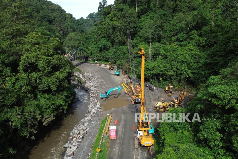 Foto udara pengerjaan perbaikan ruas jalan nasional di kawasan cagar alam Lembah Anai, Tanah Datar, Sumatera Barat, Sabtu (1/6/2024). Balai Pelaksana Jalan Nasional (BPJN) Sumbar menyebut pengerjaan perbaikan jalan nasional yang putus akibat banjir bandang itu ditargetkan selesai dan bisa dilewati kembali tanggal 21 Juli 2024 dan saat ini sedang dalam proses percepatan perbaikan dengan menurunkan 32 alat berat. 