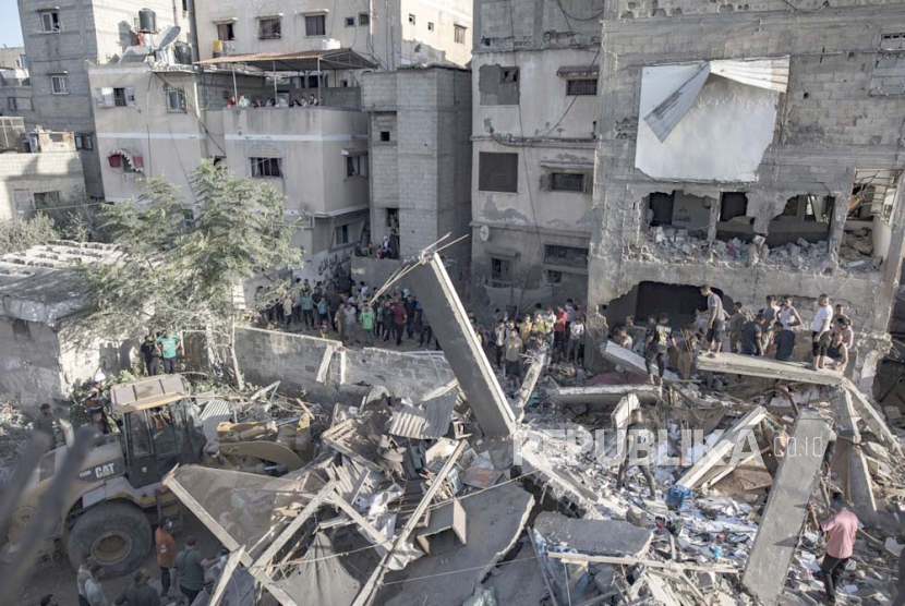 Warga Palestina mencari mayat dan korban selamat di antara puing-puing bangunan tempat tinggal menyusul serangan udara Israel di kamp pengungsi Khan Younis di Jalur Gaza selatan, 4 November 2023.