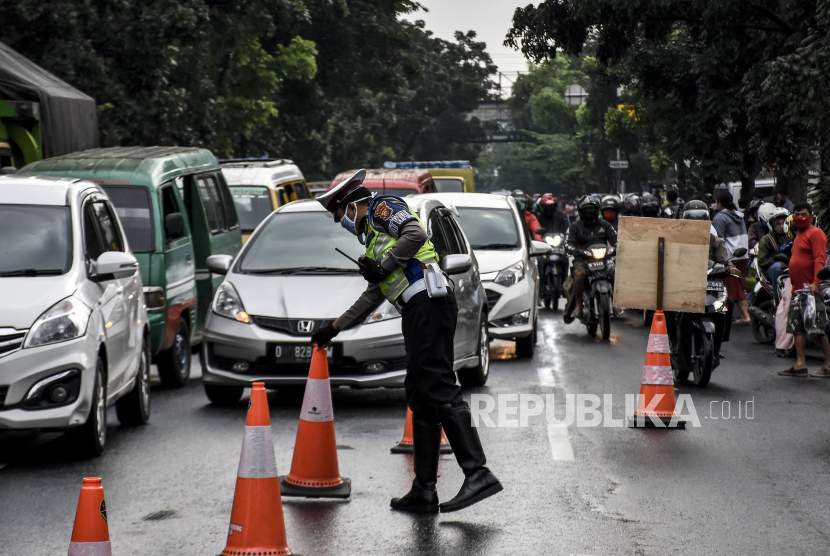 Petugas gabungan mengatur arus lalu lintas di pos pemeriksaan Pembatasan Sosial Berskala Besar (PSBB). Ilustrasi