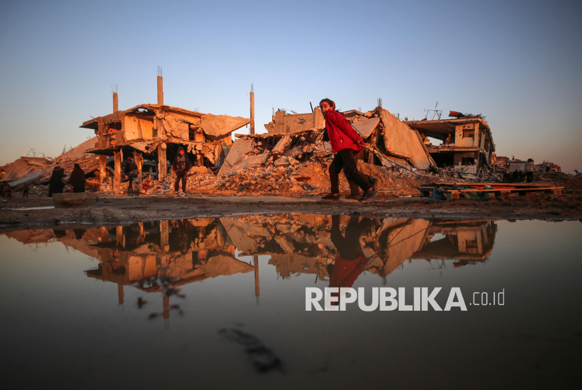 Seorang anak Palestina mengangkut barang-barang mereka yang tersisa di sepanjang Jalan Salah al-Din di antara rumah-rumah yang hancur di lingkungan Al-Zaytoun di Kota Gaza, Jumat (14/2/2025). Warga Palestina telah kembali ke rumah mereka pasca adanya genjatan senjata. Namun mereka dihadapkan pada persoalan membangun kembali tempat tinggal mereka yang sebagian besar hancur akibat serangan darat dan udara Israel. Warga Gaza, kini hidup diantara reruntuhan bangunan, mencoba membangun kembali rumah-rumah mereka dengan kemampuan seadanya.