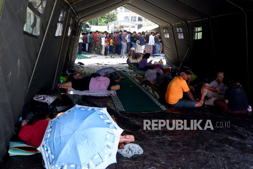 Pengungsi beristirahat di tenda darurat yang didirikan di halaman Kantor Denjasa Angkutan dan Denhar Jasa Int Bekangdam XVII/Cenderawasih di Weref, Kota Jayapura, Papua, Jumat (10/2/2023). Berdasarkan data Badan Penanggulangan Bencana Daerah (BPBD) Papua, akibat gempa magnitudo 5,4 yang terjadi pada 9 Februari 2023 itu mengakibatkan empat korban jiwa, 2.261 orang mengungsi, dan puluhan bangunan mengalami kerusakan ringan hingga berat. 