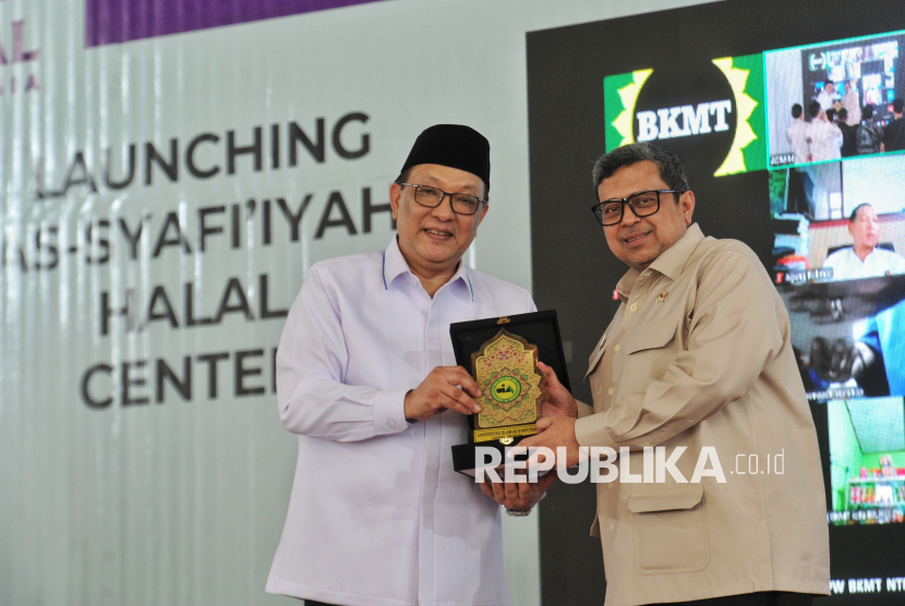 Kepala Badan Penyelenggara Jaminan Produk Halal (BPJPH) Haikal Hassan (kanan) menerima cinderamata Dewan Pembina As-Syafiiyah Halal Center Dailami Firdaus (kiri) menyampaikan paparan terkait produk halal saat Peluncuran As-Syafiiyah Halal Center di Graha Alawiyah, Bekasi, Jawa Barat, Rabu (8/1/2025). Universitas Islam As-Syafiiyah (UIA) resmi mendirikan halal center sebagai upaya meningkatkan jaminan produk halal bagi umat muslim.