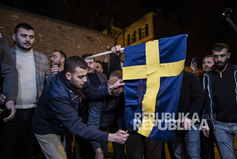 Pengunjuk rasa membakar bendera Swedia di depan Konsulat Jenderal Swedia selama protes di Istanbul, Turki, 21 Januari 2023. Politikus sayap kanan Swedia-Denmark Rasmus Paludan diizinkan mengadakan demonstrasi dan membakar salinan Alquran di depan gedung Kedutaan Besar Turki di Stockholm pada 21 Januari 2023.