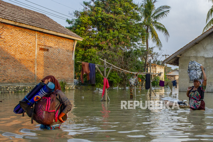 Warga menyelamatkan barang miliknya saat banjir di Desa Karangligar, Karawang, Jawa Barat. Warga yang jadi korban banjir di pesisir Karawang, Jabar belum mendapatkan bantuan.
