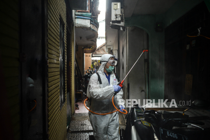 Petugas menyemprotkan cairan disinfektan di permukiman padat penduduk kawasan Kebon Melati, Kelurahan Kebon Kacang Jakarta Pusat, Sabtu (28/3). 