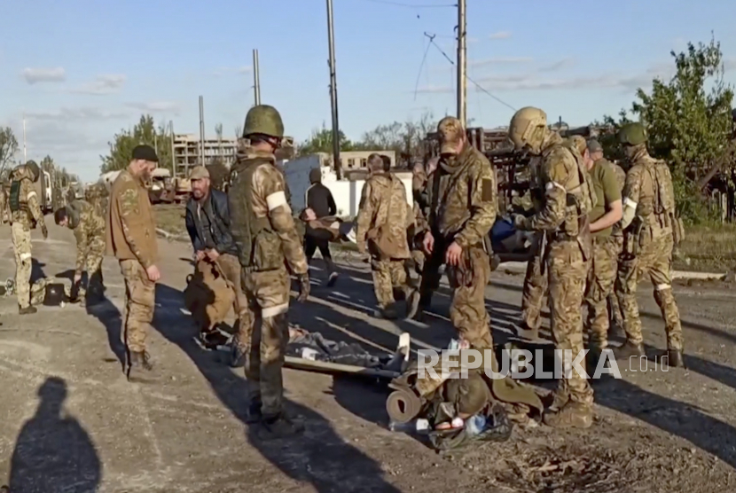  Gambar diam selebaran yang diambil dari video selebaran yang disediakan oleh layanan pers Kementerian Pertahanan Rusia menunjukkan tentara Rusia menggeledah prajurit Ukraina saat mereka dievakuasi dari pabrik baja Azovstal yang terkepung di Mariupol, Ukraina, 17 Mei 2022.