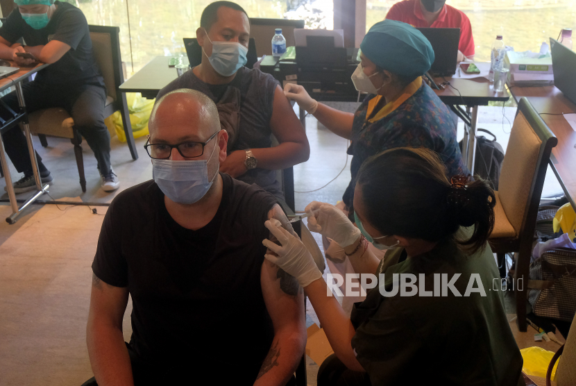 Vaksinator menyuntikkan vaksin COVID-19 kepada Warga Negara Asing (WNA) yang menjalani vaksinasi dosis kedua di wilayah Sanur, Denpasar, Bali, Selasa (22/6/2021). Sebanyak 537 orang WNA yang menerima vaksin dosis pertama pada bulan Maret 2021 tersebut saat ini menjalani vaksinasi dosis kedua untuk mencapai 