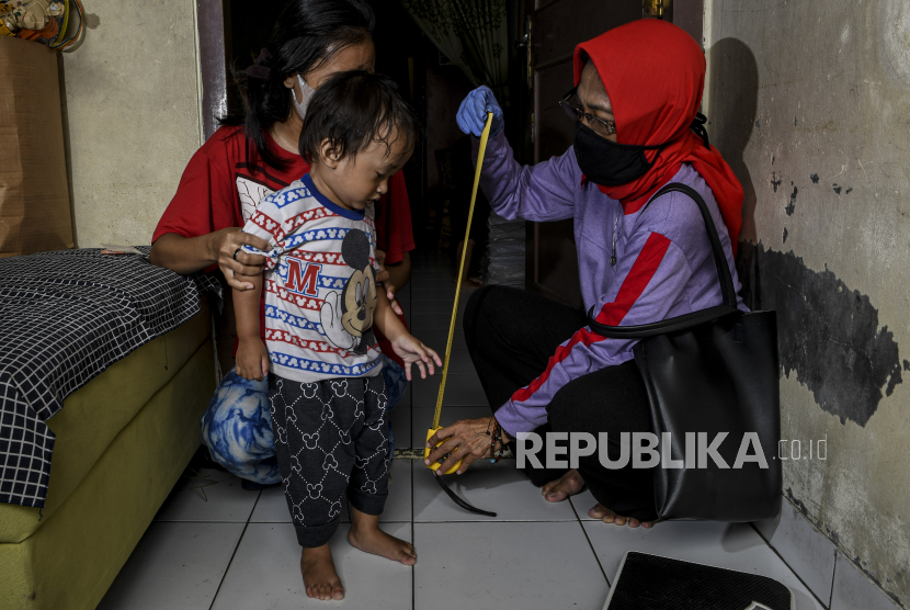 Kader Posyandu mengukur tinggi badan dari bocah saat melakukan pelayanan jemput bola di kawasan Green Garden, Rorotan, Jakarta Utara, beberapa waktu lalu. 