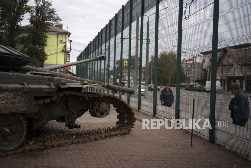 Orang-orang melihat tampilan kendaraan militer Rusia yang hancur selama Hari Pembela Ukraina di Kryvyi Rih, Ukraina, Jumat, 14 Oktober 2022.