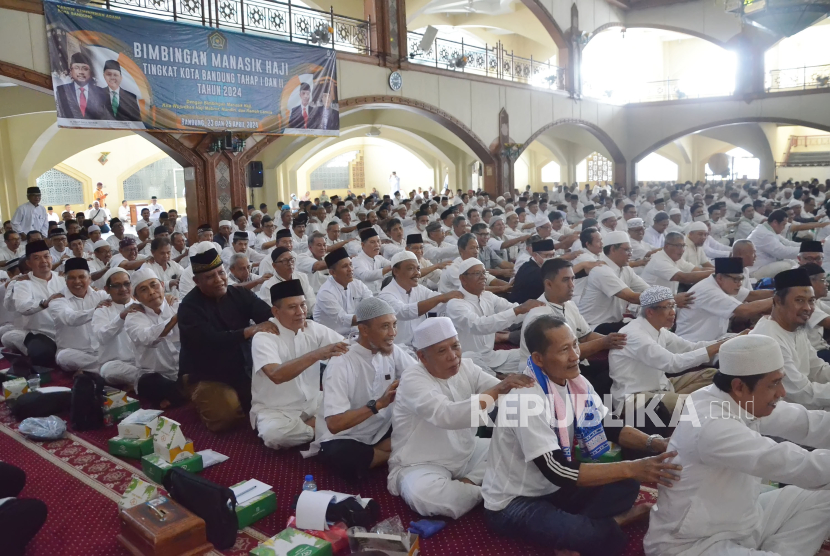 Para calon jemaah haji saling memijit saat mengikuti Bimbingan Manasik Haji Tingkat Kota Bandung yang diikuti oleh ribuan calon jemaah haji, di Masjid Pusdai Kota Bandung, Jawa Barat