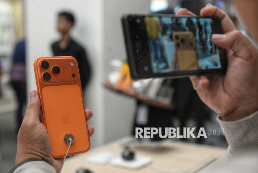 Calon pembeli memotret iPhone 17 di Mal Grand Indonesia, Jakarta, Jumat (17/10/2025). Apple mengubah pola peluncuran iPhone, dengan menggeser sebagian model dari jadwal rilis bulan September ke awal tahun.