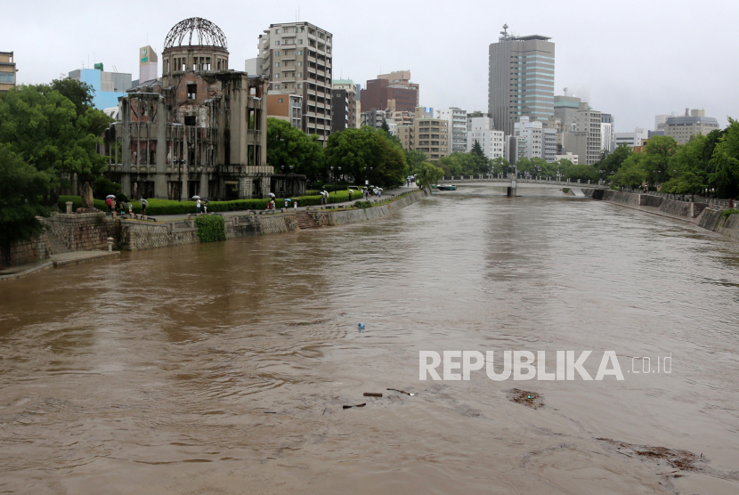 Sungai Motoyasu terlihat naik di sebelah Kubah Bom Atom (kiri) di Hiroshima, Jepang barat, 13 Agustus 2021. Badan Meteorologi Jepang mengeluarkan peringatan hujan tingkat tinggi di Jepang barat karena negara itu dilanda hujan deras yang memicu tanah longsor .