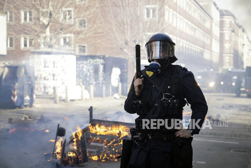 File- Petugas polisi Denmark berjaga di dekat api yang dinyalakan oleh orang-orang yang melakukan protes setelah seorang provokator sayap kanan melemparkan Alquran ke udara.