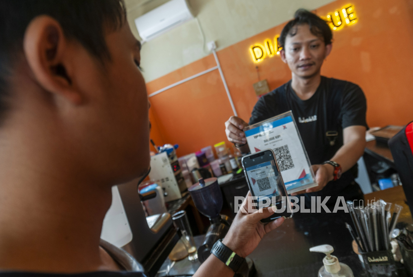Pembeli bertransaksi menggunakan QRIS di salah satu toko di Rangkasbitung, Lebak, Banten, Jumat (18/3/2022). Bank Indonesia menargetkan 15 juta merchant Usaha Mikro, Kecil, dan Menengah (UMKM) mulai menggunakan Quick Response Indonesia Standart (QRIS) pada tahun 2022 guna mendorong perluasan digitalisasi UMKM. 